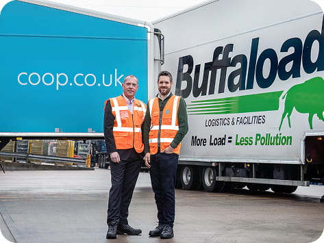 Two males standing in front of a lorry